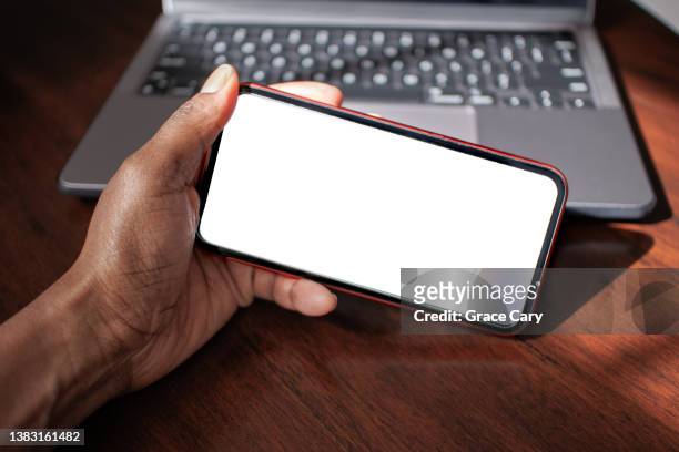woman holds smart phone with blank screen - horisontell bildbanksfoton och bilder