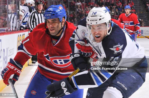 Scott Gomez of the Montreal Canadiens battles for the puck with Andrew Ladd of the Winnipeg Jets during the NHL game on February 5, 2012 at the Bell...