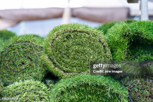 artificial synthetic grass rolled up in a store on display for sale - kunstgras stockfoto's en -beelden