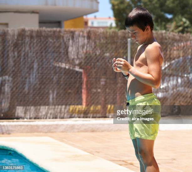 child at the edge of the pool waiting for the right moment to make a jump - calções azuis - fotografias e filmes do acervo