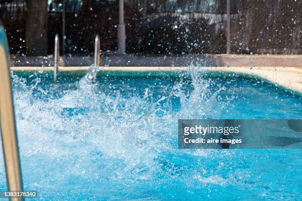 close up to the splashing water of the pool after a launch - schwimmbad leiter stock-fotos und bilder