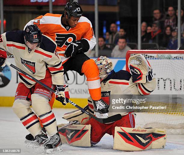 Wayne Simmonds of the Philadelphia Flyers leaps in the air in front of Henrik Lundqvist of the New York Rangers as he attempts to deflect a shot on...
