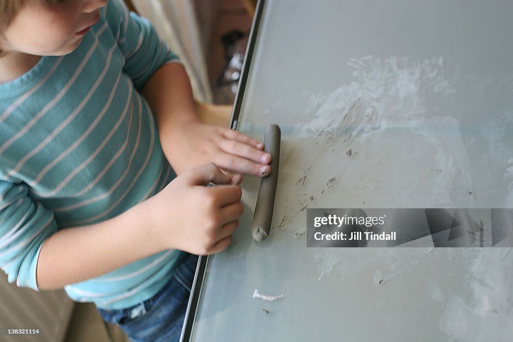 Boy rolling clay