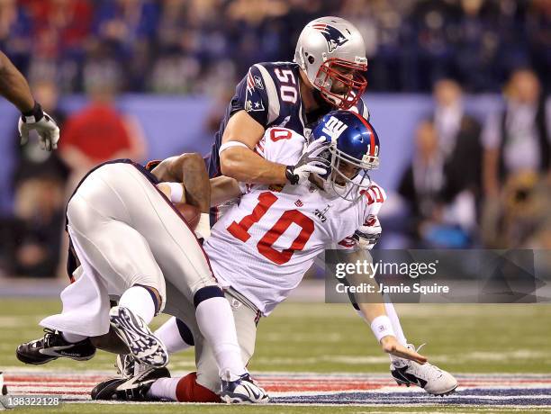 Quarterback Eli Manning of the New York Giants is sacked for a loss on third down by Mark Anderson of the New England Patriots in the first quarter...