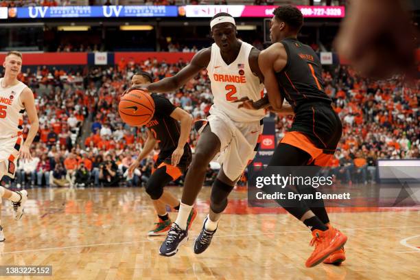 John Bol Ajak of the Syracuse Orange drives to the basket as Anthony Walker of the Miami Hurricanes guards him during the first half at the Carrier...