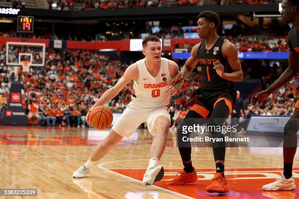 Jimmy Boeheim of the Syracuse Orange drives to the basket as Anthony Walker of the Miami Hurricanes guards him during the first half at the Carrier...