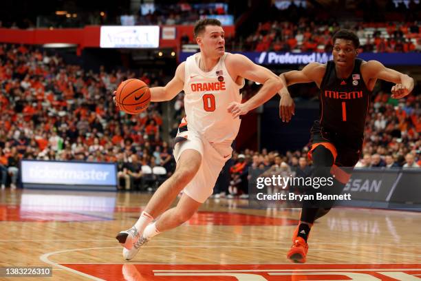 Jimmy Boeheim of the Syracuse Orange drives to the basket as Anthony Walker of the Miami Hurricanes guards him during the first half at the Carrier...