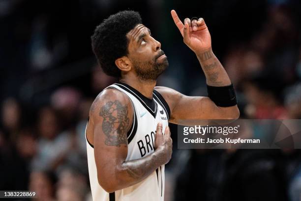 Kyrie Irving of the Brooklyn Nets looks up and points to the sky in the fourth quarter during their game against the Charlotte Hornets at Spectrum...