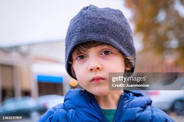 serious pensive little boy looking at the camera wearing a toque hat - traditionele koksmuts stockfoto's en -beelden