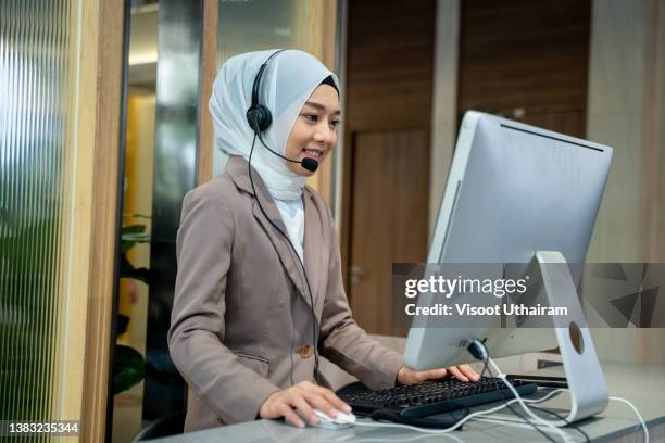 friendly operator woman agent with headsets working in a call center,smiling support phone operator woman wearing hijab working in customer service. - cut in half stock-fotos und bilder