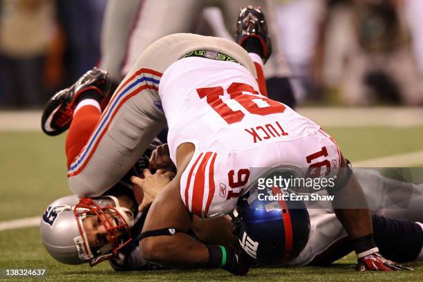 Quarterback Tom Brady of the New England Patriots is sacked by Justin Tuck of the New York Giants in the second half during Super Bowl XLVI at Lucas...