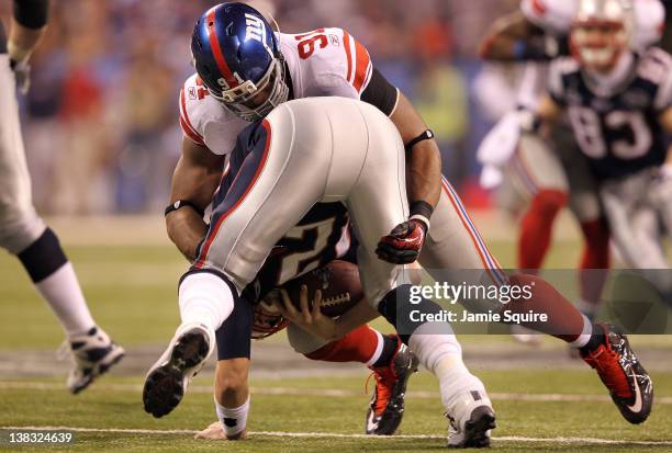 Tom Brady of the New England Patriots gets sacked by Justin Tuck of the New York Giants in the third quarter during Super Bowl XLVI at Lucas Oil...