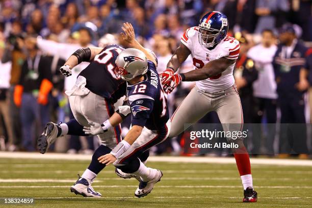 Tom Brady of the New England Patriots falls to the ground after throwing an interception to Chase Blackburn of the New York Giants over Rob...