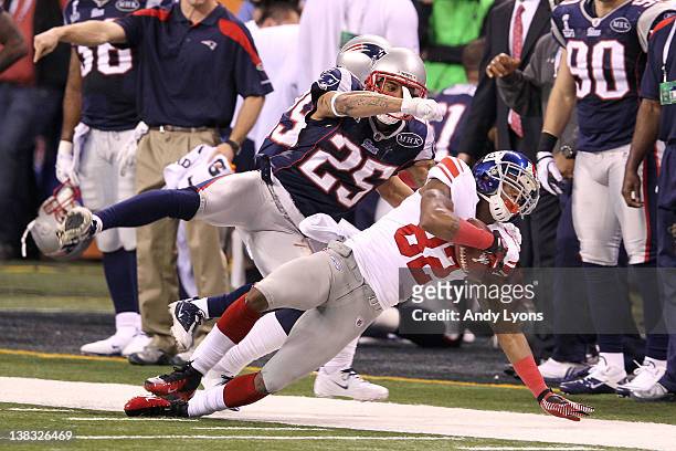 Mario Manningham of the New York Giants catches a 38 yard pass from Eli Manning over Patrick Chung and Sterling Moore of the New England Patriots in...