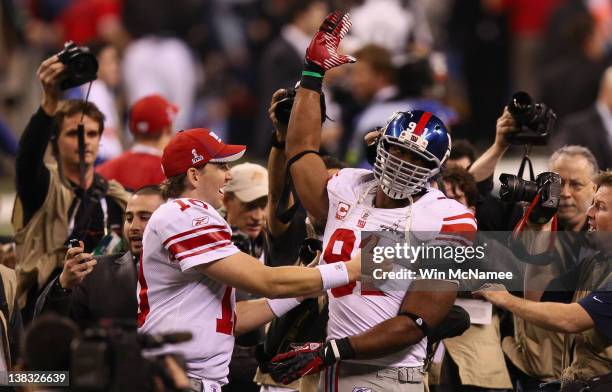 Eli Manning of the New York Giants celebrates with Justin Tuck after defeating the New England Patriots to win the Super Bowl XLVI at Lucas Oil...