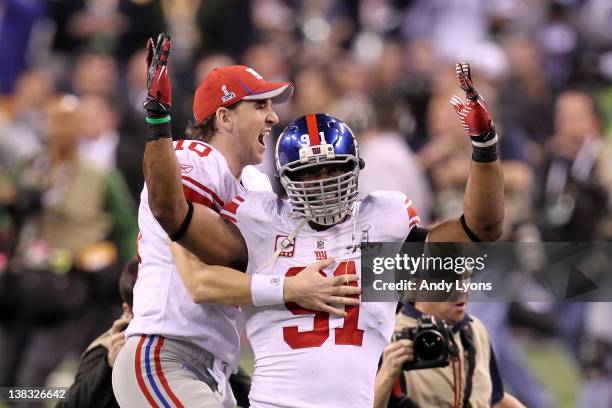 Eli Manning of the New York Giants celebrates with Justin Tuck after defeating the New England Patriots in Super Bowl XLVI at Lucas Oil Stadium on...