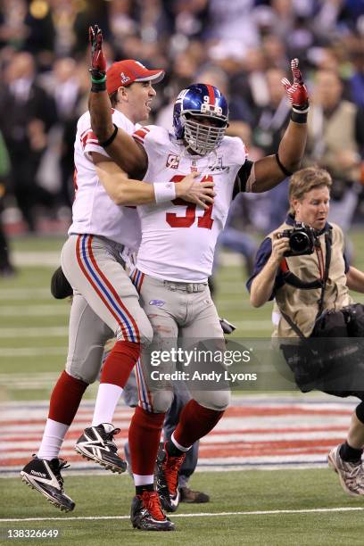 Eli Manning of the New York Giants celebrates with Justin Tuck after defeating the New England Patriots in Super Bowl XLVI at Lucas Oil Stadium on...