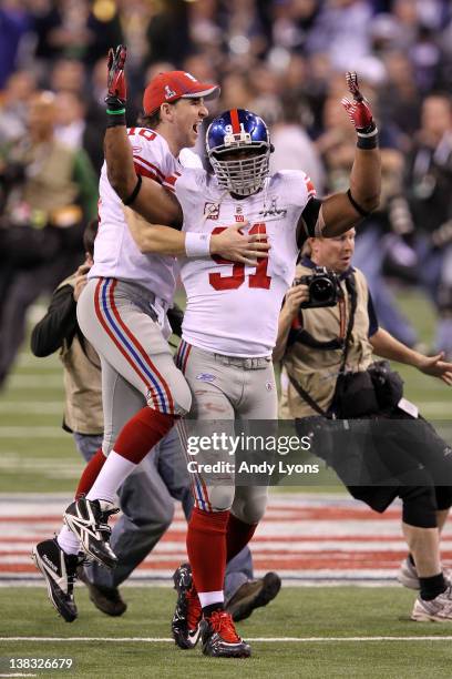 Eli Manning of the New York Giants celebrates with Justin Tuck after defeating the New England Patriots in Super Bowl XLVI at Lucas Oil Stadium on...