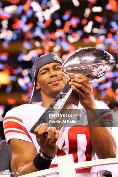 Victor Cruz of the New York Giants hoist the Vince Lombardi Trophy after defeating the New England Patriots in Super Bowl XLVI at Lucas Oil Stadium...