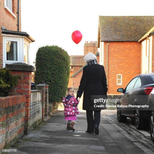 girl holding red balloon with grandmother - windsor stock pictures, royalty-free photos & images