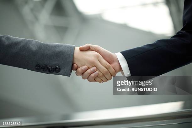 businessman and businesswoman shaking hands - shake ストックフォトと画像