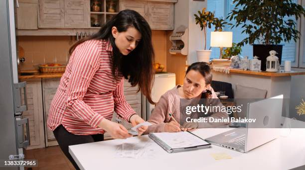 pregnant woman helping her friend do her home finances. - student loan stockfoto's en -beelden