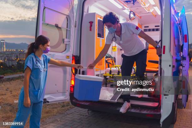 medical team in a hurry carrying organ transplants box by ambulance during pandemic - organ transplant transport stock pictures, royalty-free photos & images