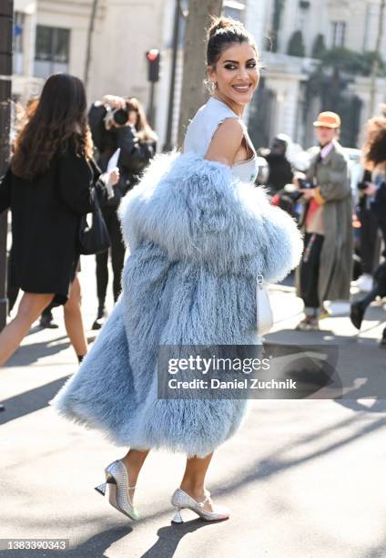 Camila Coelho seen wearing a light blue faux fur coat and silver shoes outside the Miu Miu show during Paris Fashion Week A/W 2022 on March 08, 2022...