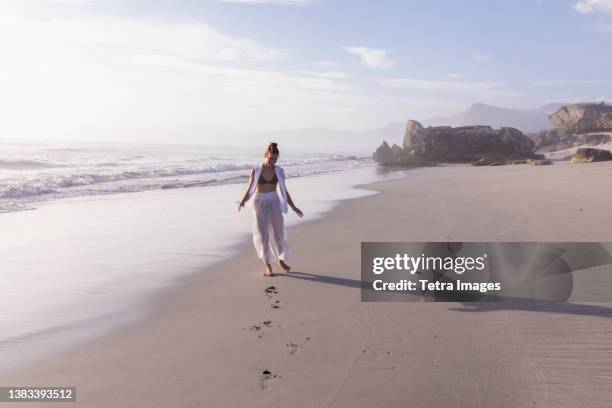 south africa, hermanus, girl (16-17) walking on sopiesklip beach in walker bay nature reserve - hermanus stock pictures, royalty-free photos & images