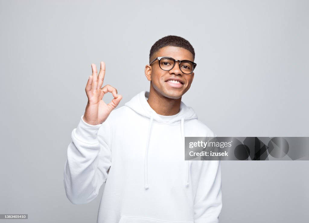 Cheerful young man gesturing ok
