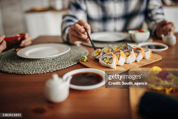 couple having homemade sushi - maki sushi stockfoto's en -beelden