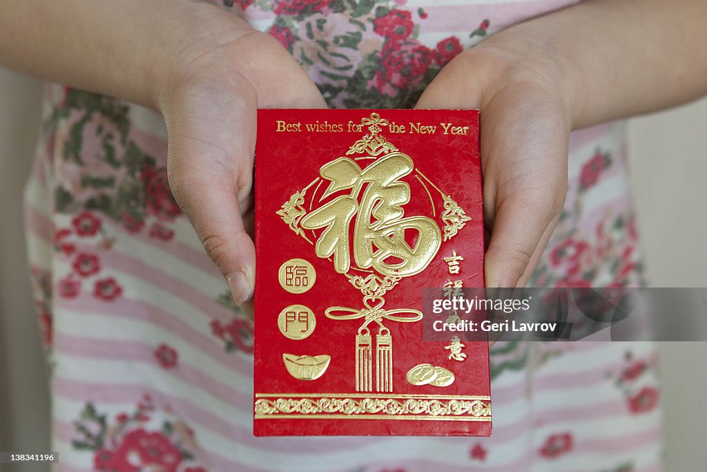 Child holding a Honbao red envelope