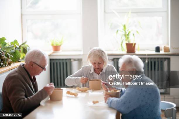 group of seniors enjoying breakfast in nursing home care center. - residential care stock-fotos und bilder