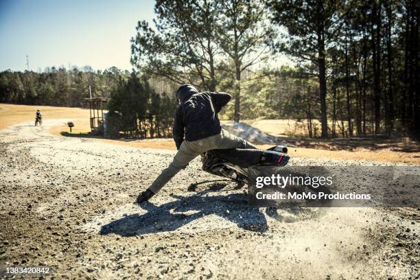 dirtbiker doing a hard turn in gravel and dirt - the moto x film experience stock-fotos und bilder