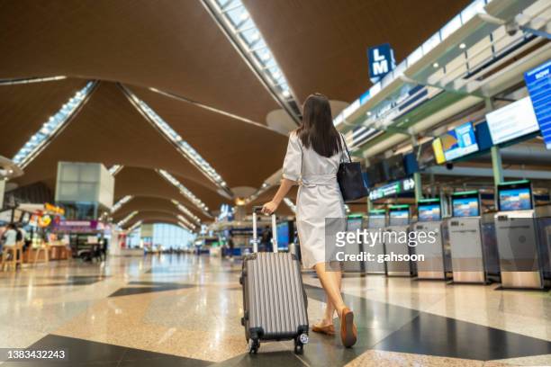 business woman walking in the airport - kuala lumpur airport stock pictures, royalty-free photos & images