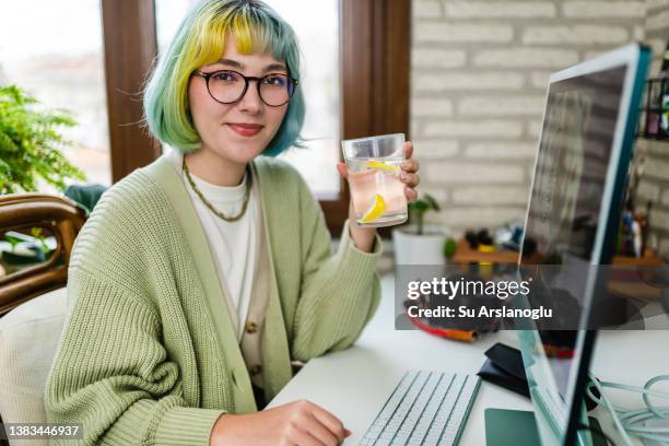 若い女性は仕事中に水を飲む - water glasses ストックフォトと画像