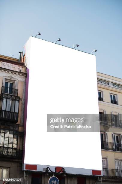 poster vuoto sulla facciata di un edificio - vertical foto e immagini stock