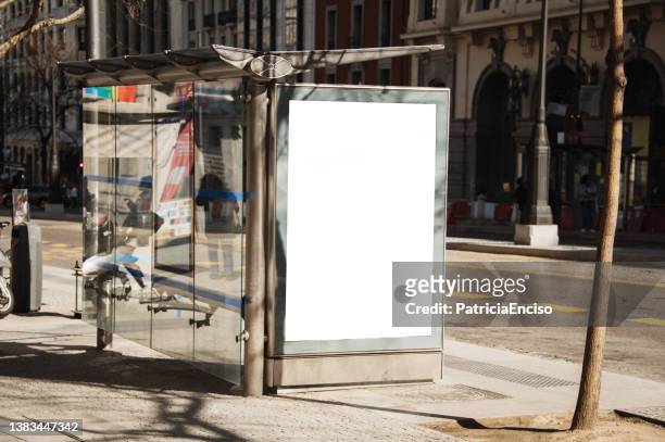 bus stop with blank poster - advertentie stockfoto's en -beelden