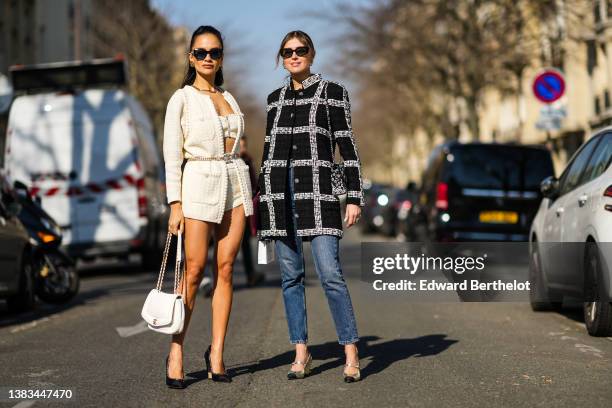 Anna Rosa Vitiello wears black sunglasses, gold earrings, a silver chain necklace from Chanel, a white wool buttoned shoulder-off / cropped top from...