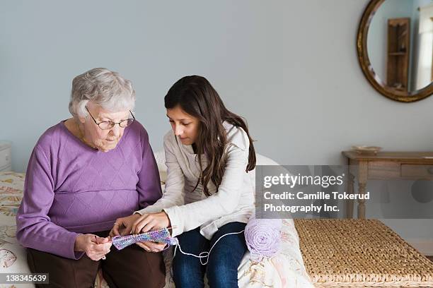 grandmother and granddaughter knitting together - old granny knitting stock-fotos und bilder