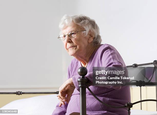 elderly woman by the edge of bed thinking - 80 89 years stock pictures, royalty-free photos & images