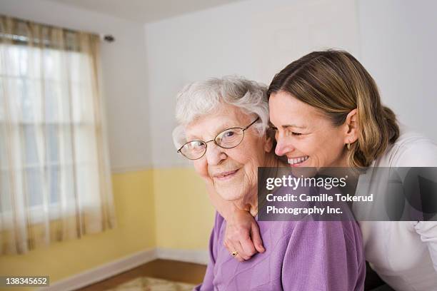 daughter hugging elderly mother - older parent stock pictures, royalty-free photos & images