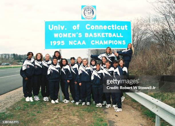Members of the University of Connecticut's NCAA national championship-winning women's basketball team pose next to a roadsign erected in their honor...