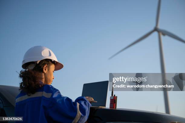 female engineer working on wind farm, using laptop. - esg stock pictures, royalty-free photos & images