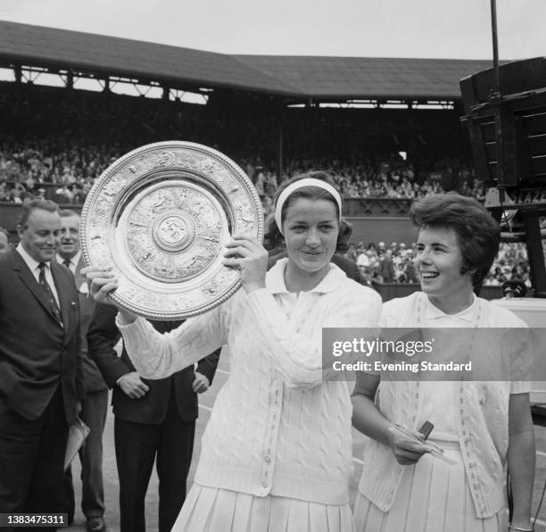 British tennis player Margaret Smith holds the Venus Rosewater Trophy after beating American tennis player Billie Jean Moffitt in the final of the...