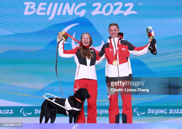 Gold medalist Carina Edlinger of Team Austria celebrates on the podium with her guide dog Riley and her guide during the medal ceremony for the...