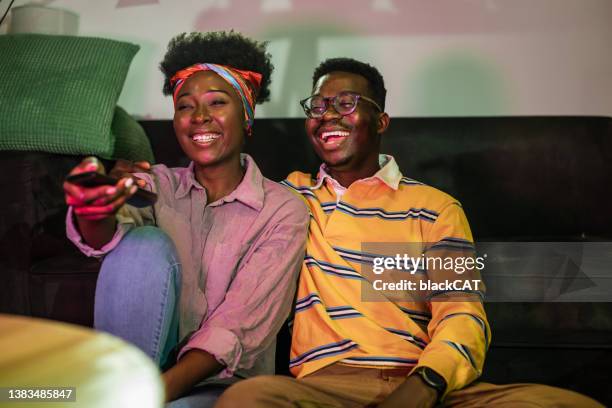 african-american couple watching tv at home - premiere of paramount pictures daddys home 2 arrivals stockfoto's en -beelden