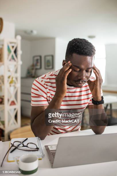 young man having a stressful day while working on a laptop - bad student stock pictures, royalty-free photos & images