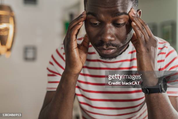 junger kerl hat einen stressigen tag und kopfschmerzen - winterdepression stock-fotos und bilder
