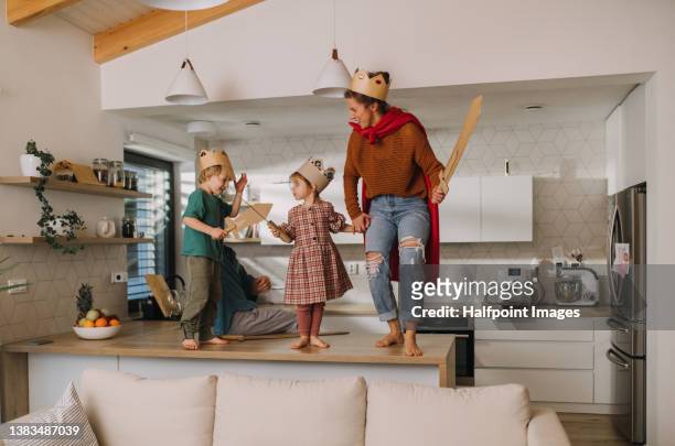 mother with two little children in kings costumes playing together at home. - king stock pictures, royalty-free photos & images